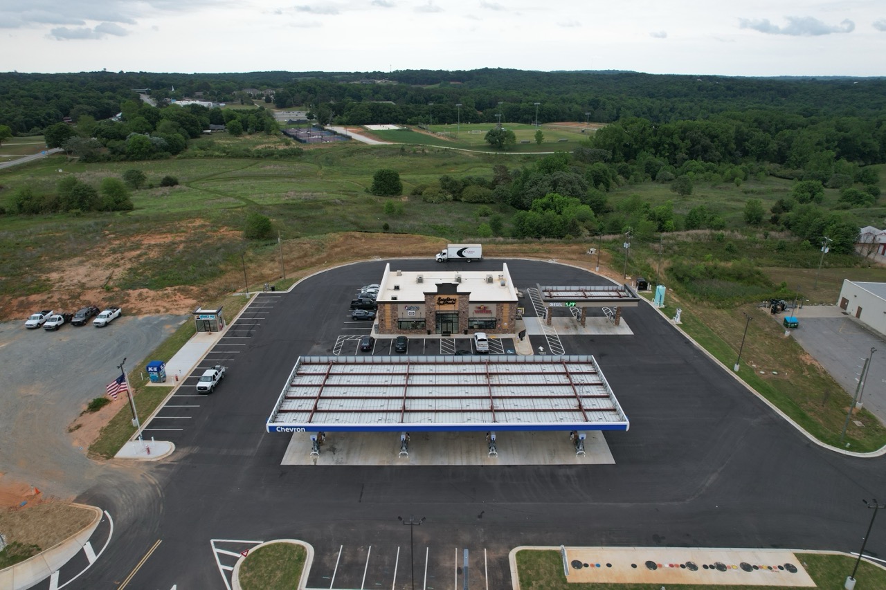 Aerial view of a steel commercial building site with retail space and fuel canopy
