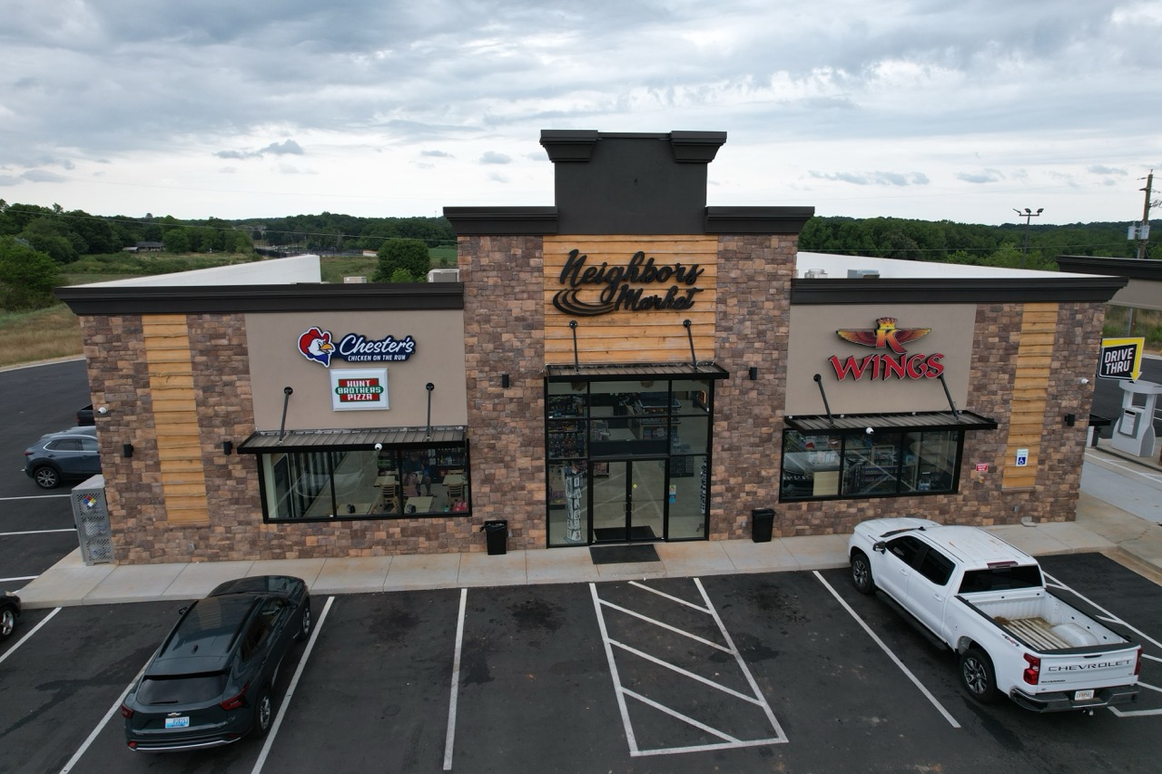 Steel commercial building with retail and restaurant tenant storefronts and drive-thru signage
